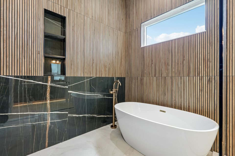 Primary bathroom with freestanding tub and dramatic stone shower